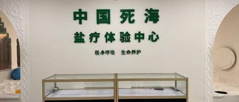 Una habitación con un cartel que dice 'Centro de Experiencia Integral del Mar de la Muerte de China' y una vitrina de vidrio.