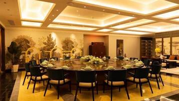 A conference room with a round table, chairs, and a chandelier.