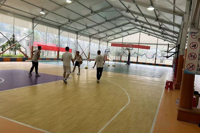 An indoor basketball court with a wooden floor and a high ceiling.