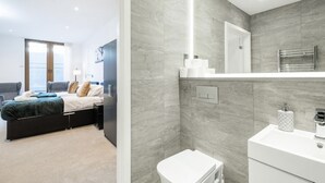 Een moderne slaapkamer met een bed, nachtkastje en uitzicht op zee.