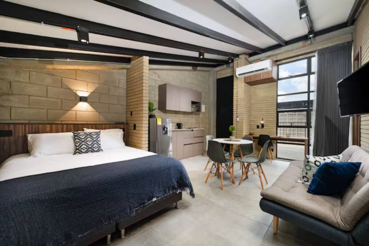Une chambre d’hôtel moderne dotée d’un grand lit, d’un coin repas et d’un canapé.