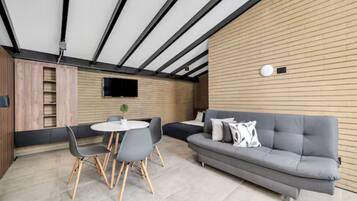 A modern interior with a grey sofa, round table, and chairs.