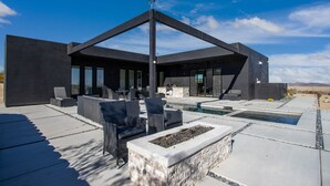 Une terrasse extérieure moderne dotée d’une piscine, d’un espace salon et d’un grand espace vitré.