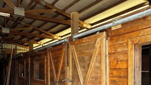 A large, open barn-like structure with high ceilings and wooden beams.