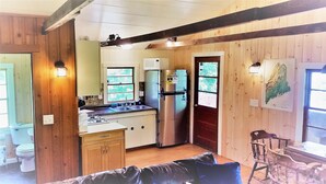 A compact kitchen with a refrigerator, sink, and wooden cabinets. - Blue Loon Camp on Pleasant Pond in Litchfield (Litchfield)