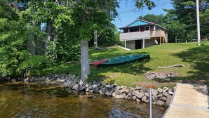 A lakeside cabin with a dock and a green canoe. - Blue Loon Camp on Pleasant Pond in Litchfield (Litchfield)
