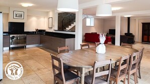 A modern kitchen with dark cabinetry, a central island, and pendant lighting.