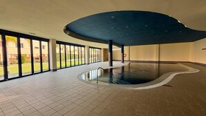 A spacious indoor swimming pool with a curved ceiling and large windows offering views of the outside. - Charming 1-bedroom apartment with AC, WiFi and amazing views in Mojácar (Mojácar)