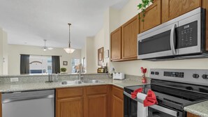 Una cocina moderna con armarios de madera, electrodomésticos de acero inoxidable y encimera de granito.
