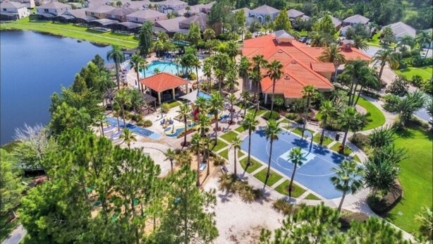 Vista aérea de un complejo turístico con varias edificaciones, un área de piscina central y vegetación circundante.