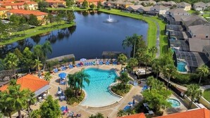Un resort con una piscina central, un lago y una fuente.