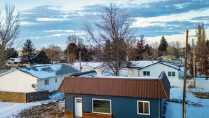 A residential area with houses, a snow-covered ground, and bare trees. - Quick Escape 2 Bedrooms n Lingle, Wy! with free Wifi & Parking (Lingle)