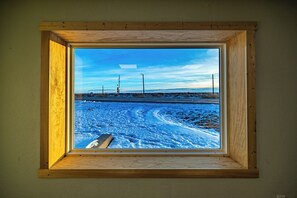 A window with a view of a snowy landscape and power lines. - Quick Escape 2 Bedrooms n Lingle, Wy! with free Wifi & Parking (Lingle)
