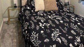 A bedroom with a bed, two bedside tables, a ceiling fan, and decorative wall stickers. - Quick Escape 2 Bedrooms n Lingle, Wy! with free Wifi & Parking (Lingle)