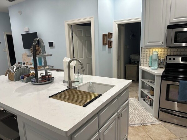 A modern kitchen with a white countertop, stainless steel appliances, and a built-in oven.