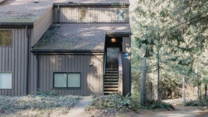 A two-story building with a wooden exterior, a visible number '416' on the door, and a staircase leading to the entrance. - Snowater Condo 45sw With a Media Room (Deming)