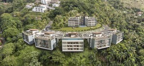 A modern hotel complex with multiple buildings, surrounded by lush greenery.