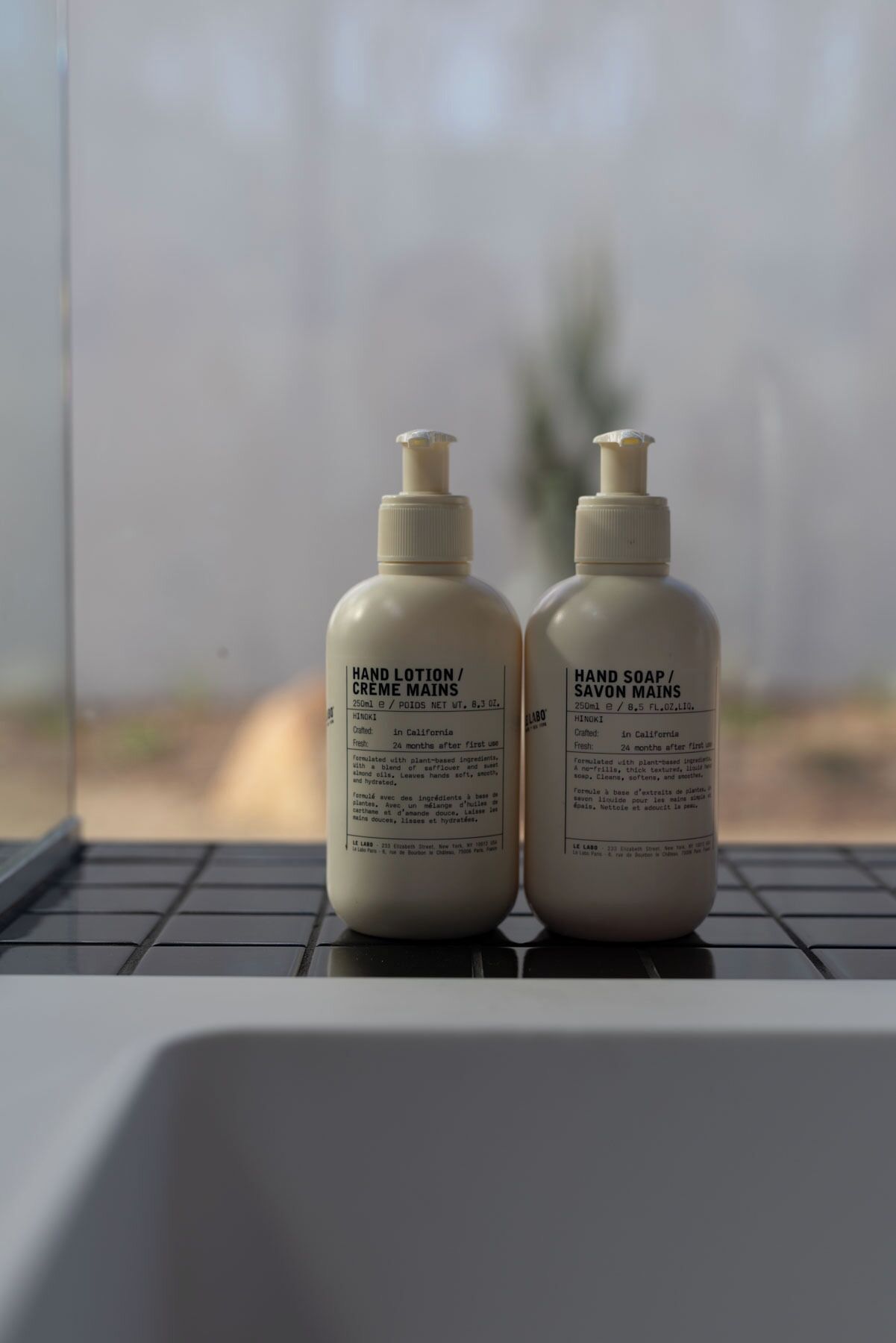 Deux flacons de crème hydratante pour les mains et de savon liquide pour les mains, posés sur le clavier d’un ordinateur portable.