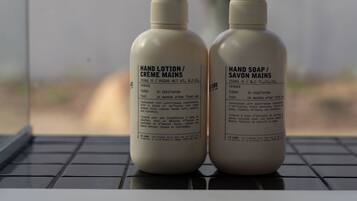 Deux flacons de crème hydratante pour les mains et de savon liquide pour les mains, posés sur le clavier d’un ordinateur portable.