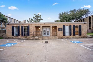 A residential laundry center with a brick facade, large windows, and a door. - Towne Plaza Apartments #104 in the Galleria Area (Houston)