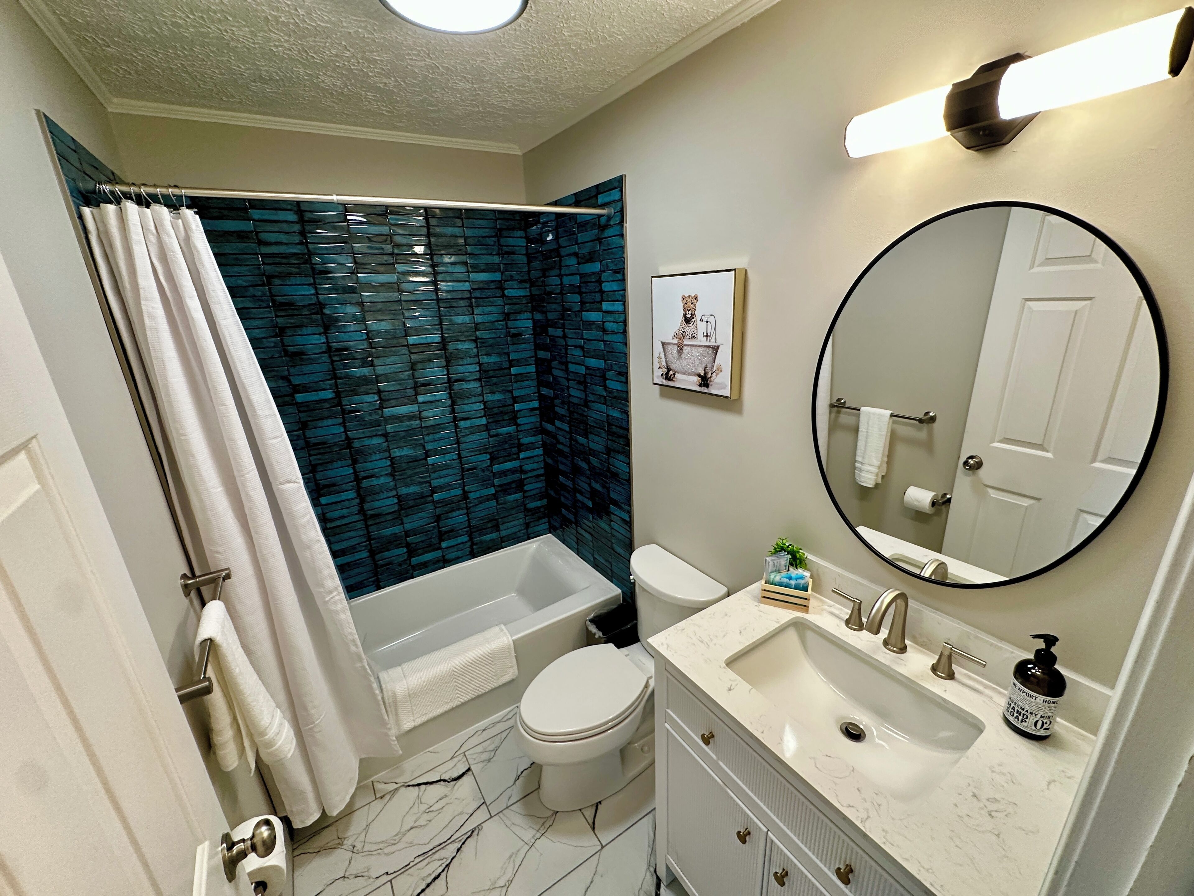 A bathroom with a bathtub, toilet, sink, and a mirror.