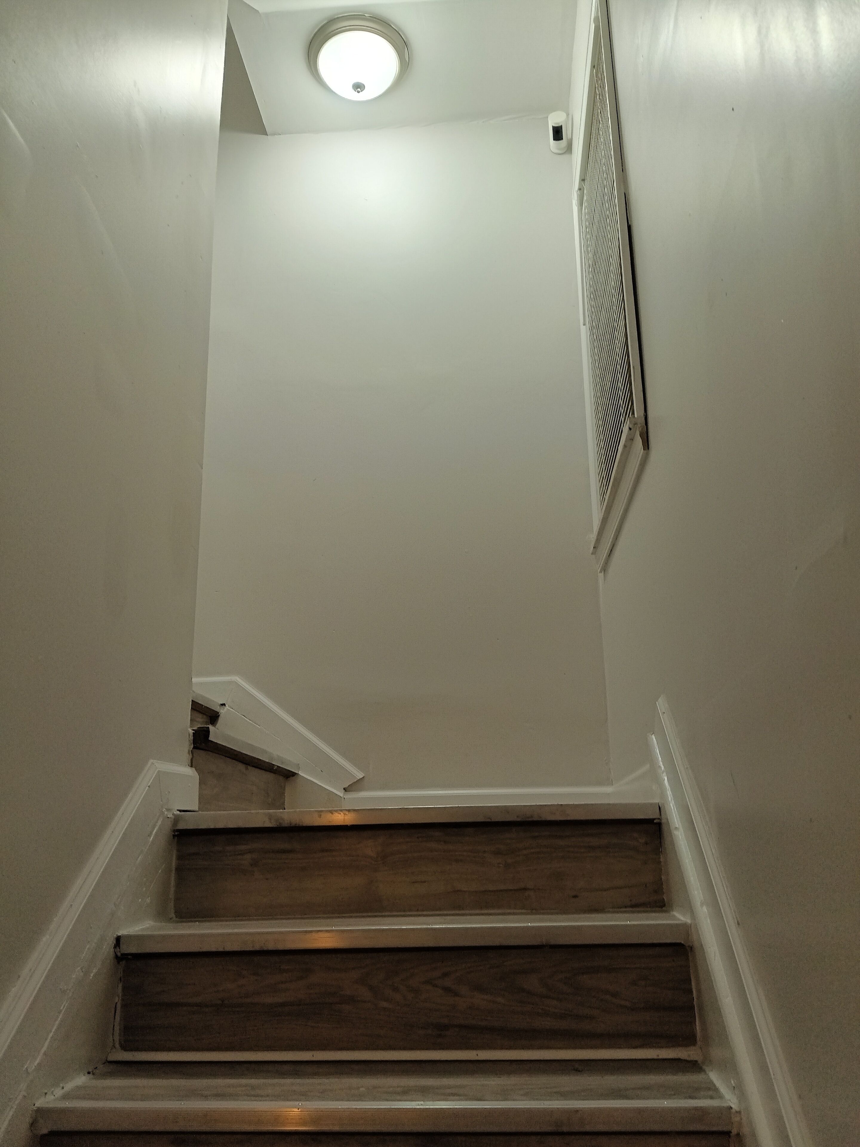 A staircase with wooden steps and white walls.