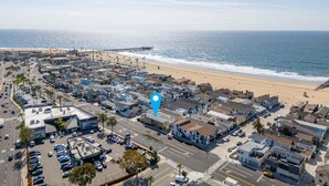 Vista aérea de un pueblo costero con playa, carreteras y edificios.