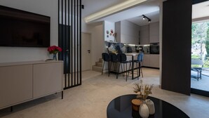 Une cuisine moderne avec un coin repas, un téléviseur sur le côté gauche et une vue sur l’extérieur.