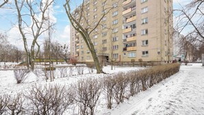 A multi-story residential building with balconies and a snow-covered ground. - Wola Smocza Pleasant Studio (Warszawa)