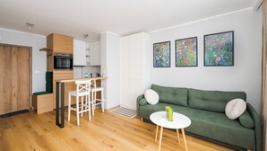 A modern apartment with a kitchen, dining area, and living room. - Wola Smocza Pleasant Studio (Warszawa)