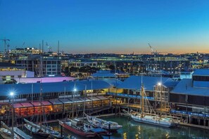 Boats are docked and moored at the marina, adjacent to a building with a glass facade.