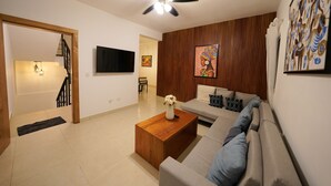 A modern living room with a sofa, coffee table, and artwork on the wall. - 3-bedroom apartment in marvelous Puerto Plata with AC, WiFi (Puerto Plata)