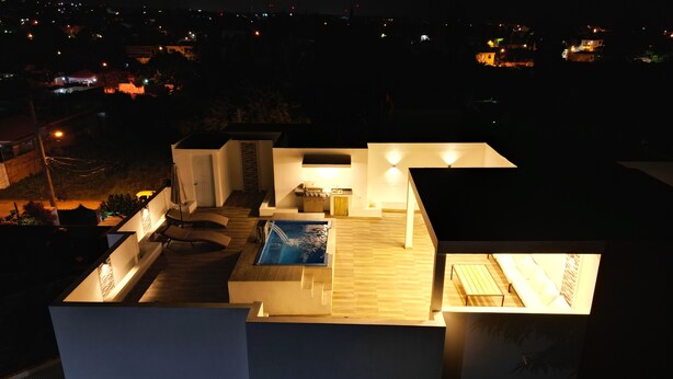 A rooftop terrace with a swimming pool, a kitchen area, and a seating area with a table and chairs. - 3-bedroom apartment in marvelous Puerto Plata with AC, WiFi (Puerto Plata)
