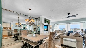 A spacious living area with a dining table, wicker chairs, a sofa, and a ceiling fan. - Free Beach Service~ Beachfront Townhome ~ Sleeps 8-GreenReef #4 (Destin)