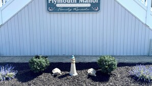 A sign for Plymouth Manor Condominiums with a family rentals logo.