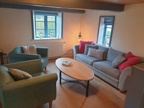 Uma sala de estar aconchegante com sofá, poltronas e mesa de centro.