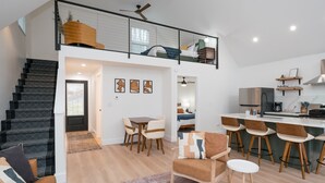 Un appartement moderne comprenant un escalier, un coin repas, une cuisine et un salon.