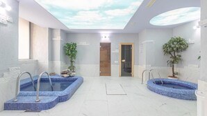 Un área de spa con dos jacuzzis, un tragaluz y una puerta de madera.