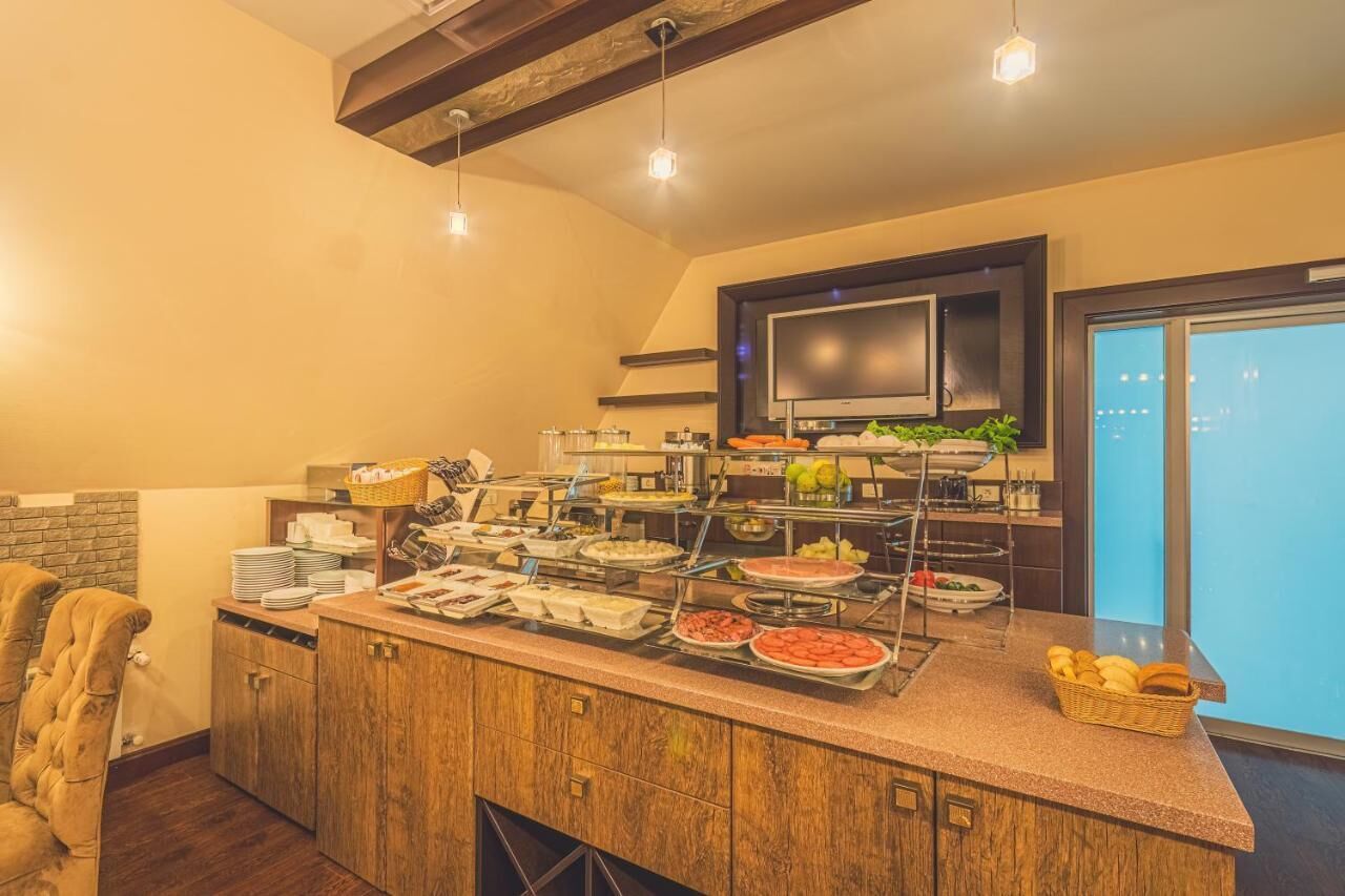A buffet area with various food items and a television on the wall.