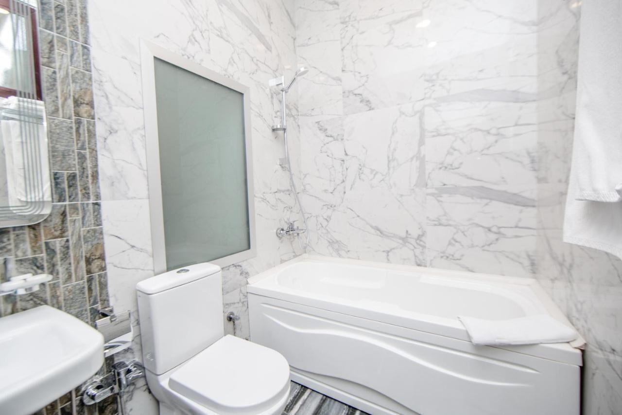 A bathroom with a white toilet, a white sink, and a white bathtub.