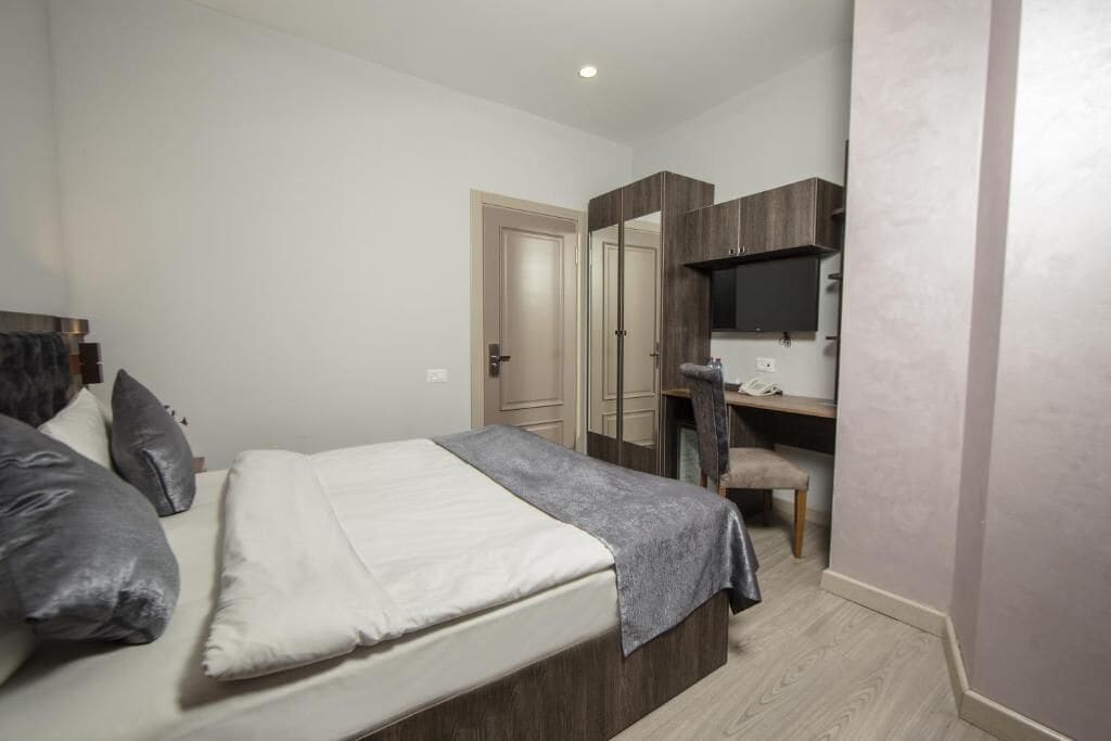 Quarto com cama, escrivaninha, cadeira e guarda-roupa.