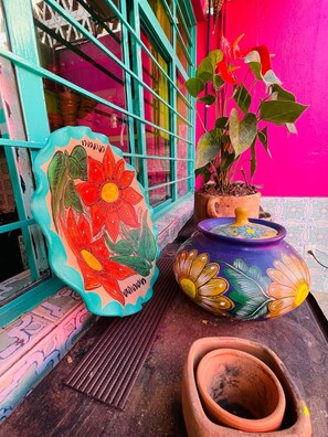 A colorful exterior with a vibrant pink wall, a teal-framed window, and a potted plant. - San Cristóbal Bleisure Hotel (San Cristóbal de las Casas)