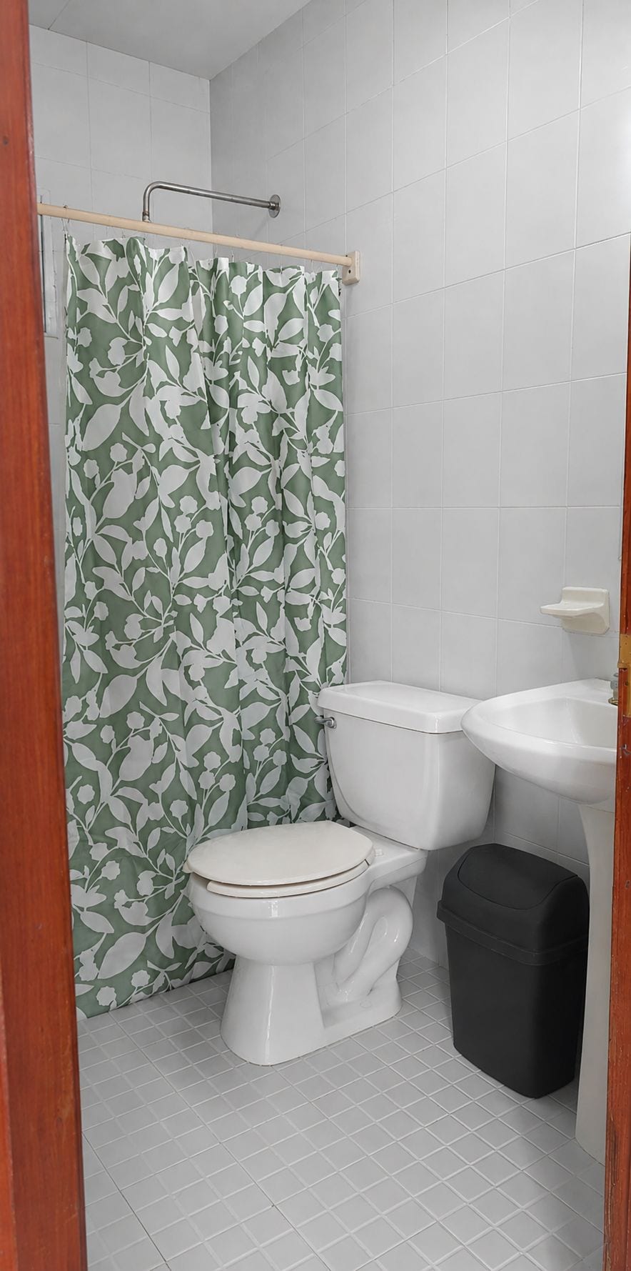 Un baño con inodoro, lavabo y cortina de ducha.