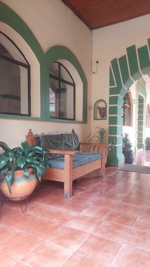 A covered outdoor seating area with a bench, potted plants, and a tiled floor. - San Cristóbal Bleisure Hotel (San Cristóbal de las Casas)