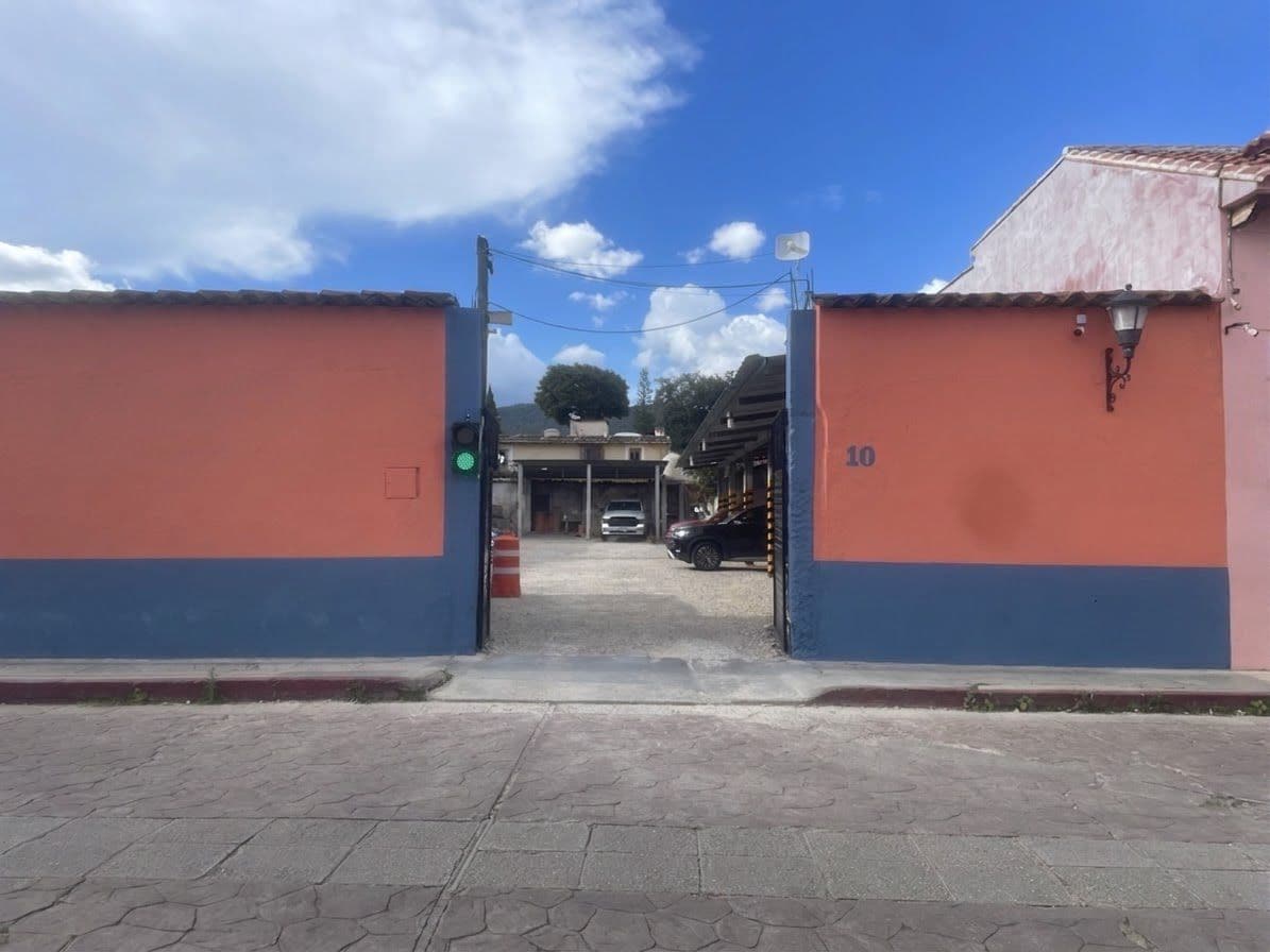 A gated entrance with a clear sky and a building in the background.