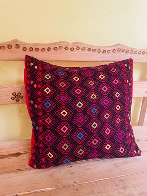 A square patterned pillow on a wooden bench. - San Cristóbal Bleisure Hotel (San Cristóbal de las Casas)