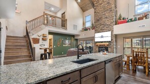 A spacious kitchen with granite countertops, wooden cabinets, and a stone accent wall. - Near Thunder Ridge: Water View, Community Indoor Pool & Free Local Attraction Tickets (Hollister)