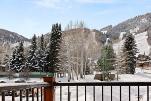 Escape to a serene mountain retreat surrounded by snow-covered trees and a ski lift in the distance.