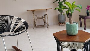A living room with a rocking chair, a table, and potted plants. - Furnished apartment, Excellent location, free parking (Cereté)