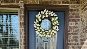 A front door with a wreath, a doormat, and a window with blinds. - Short term rental. Home away from your home. (Celina)